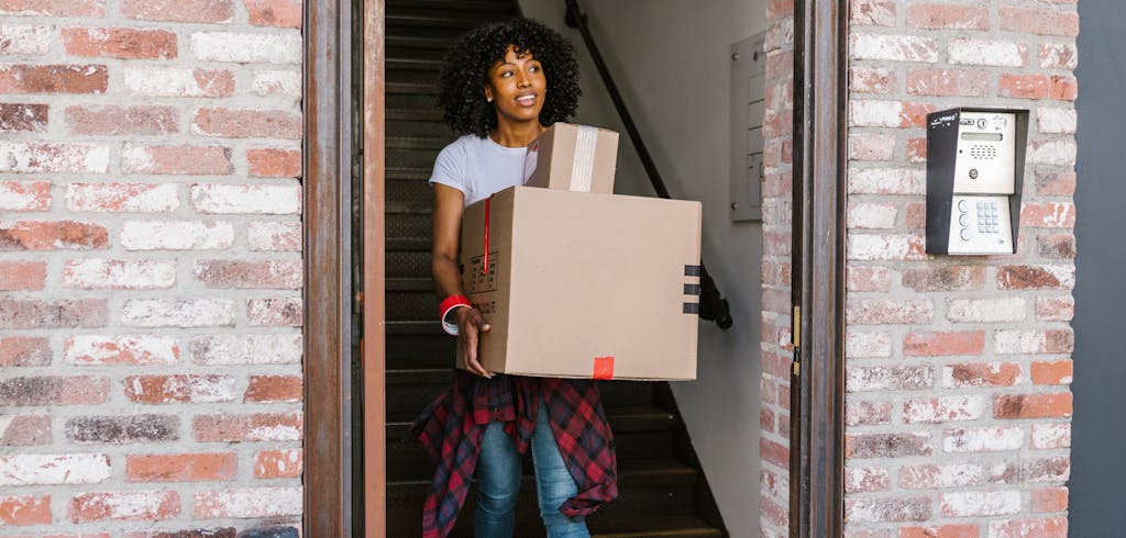 A student carrying box out of apartment.